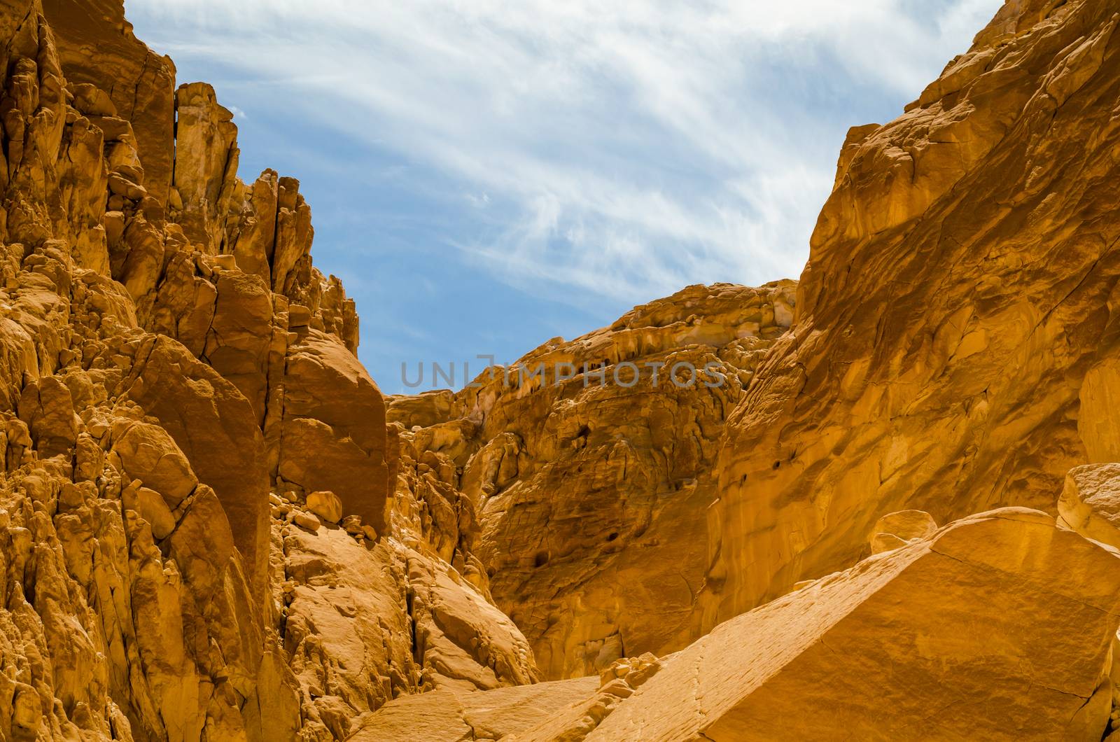 high rocky mountains against the blue sky and white clouds in the desert