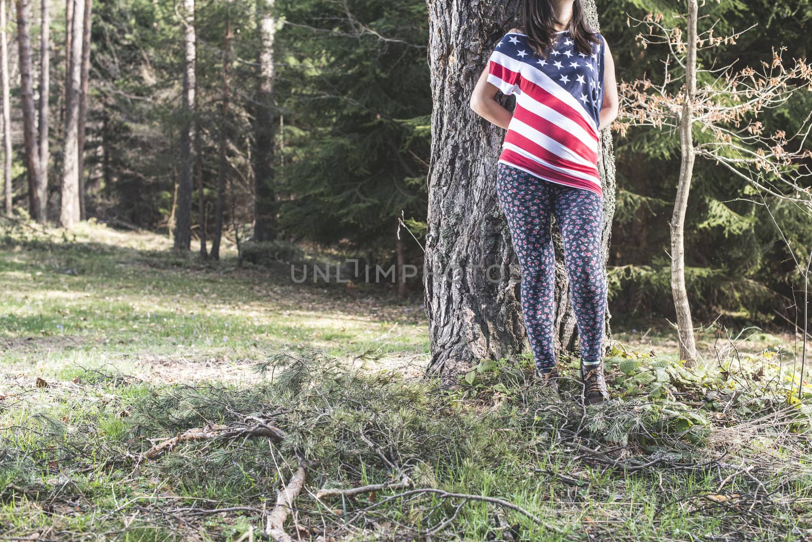 Pregnant woman in the forest. American national flag shirt