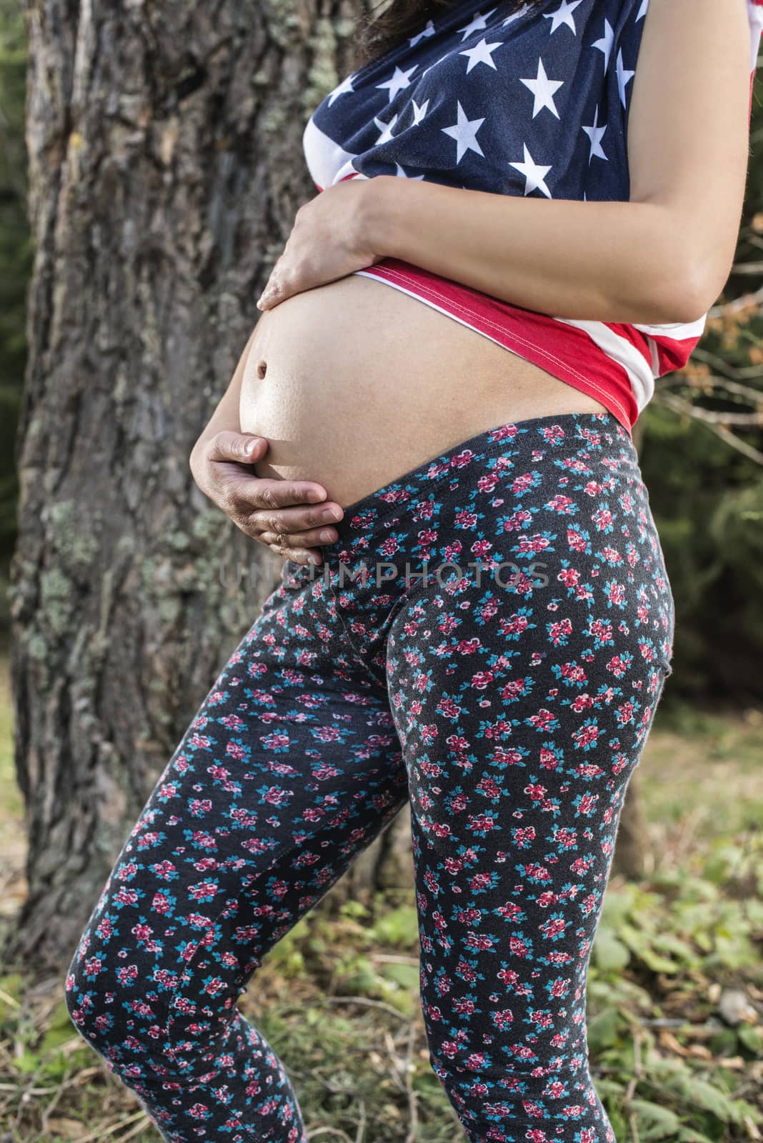 Pregnant woman in the forest. American national flag shirt