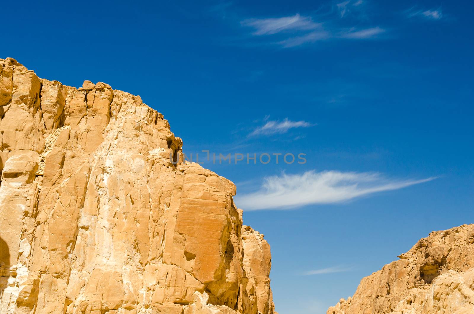high rocky mountains against the blue sky and white clouds in the desert in Egypt Dahab
