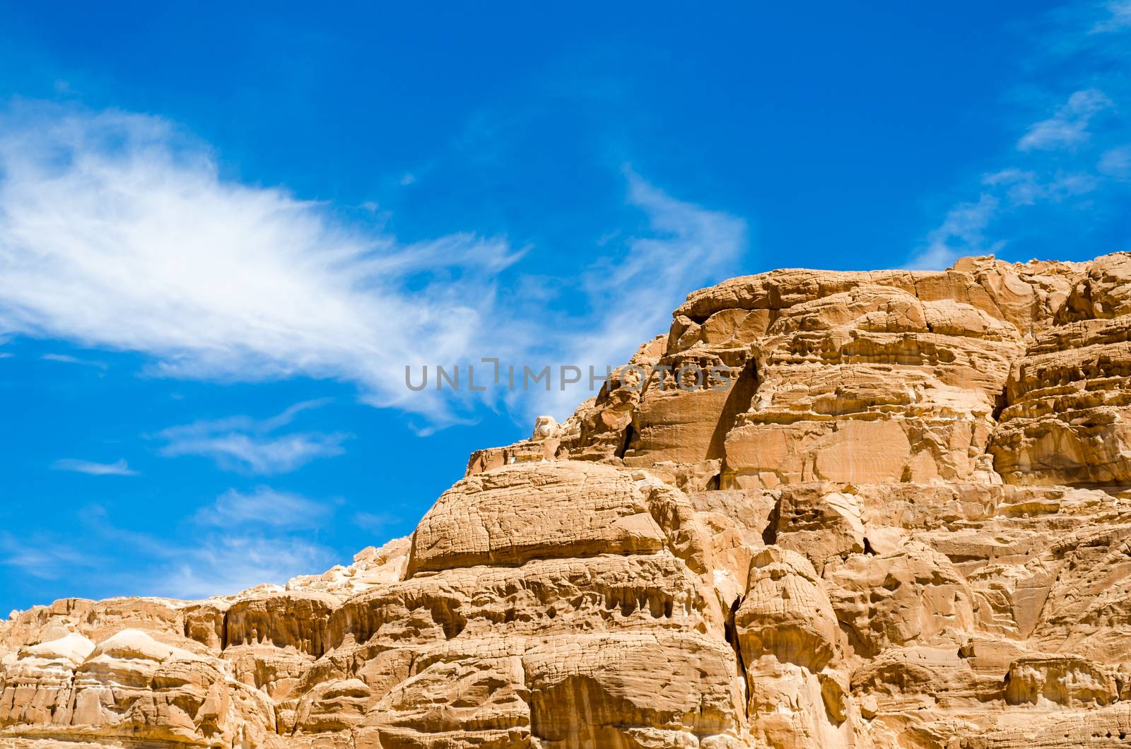 high rocky mountains in the desert against the blue sky and white clouds in Egypt Dahab