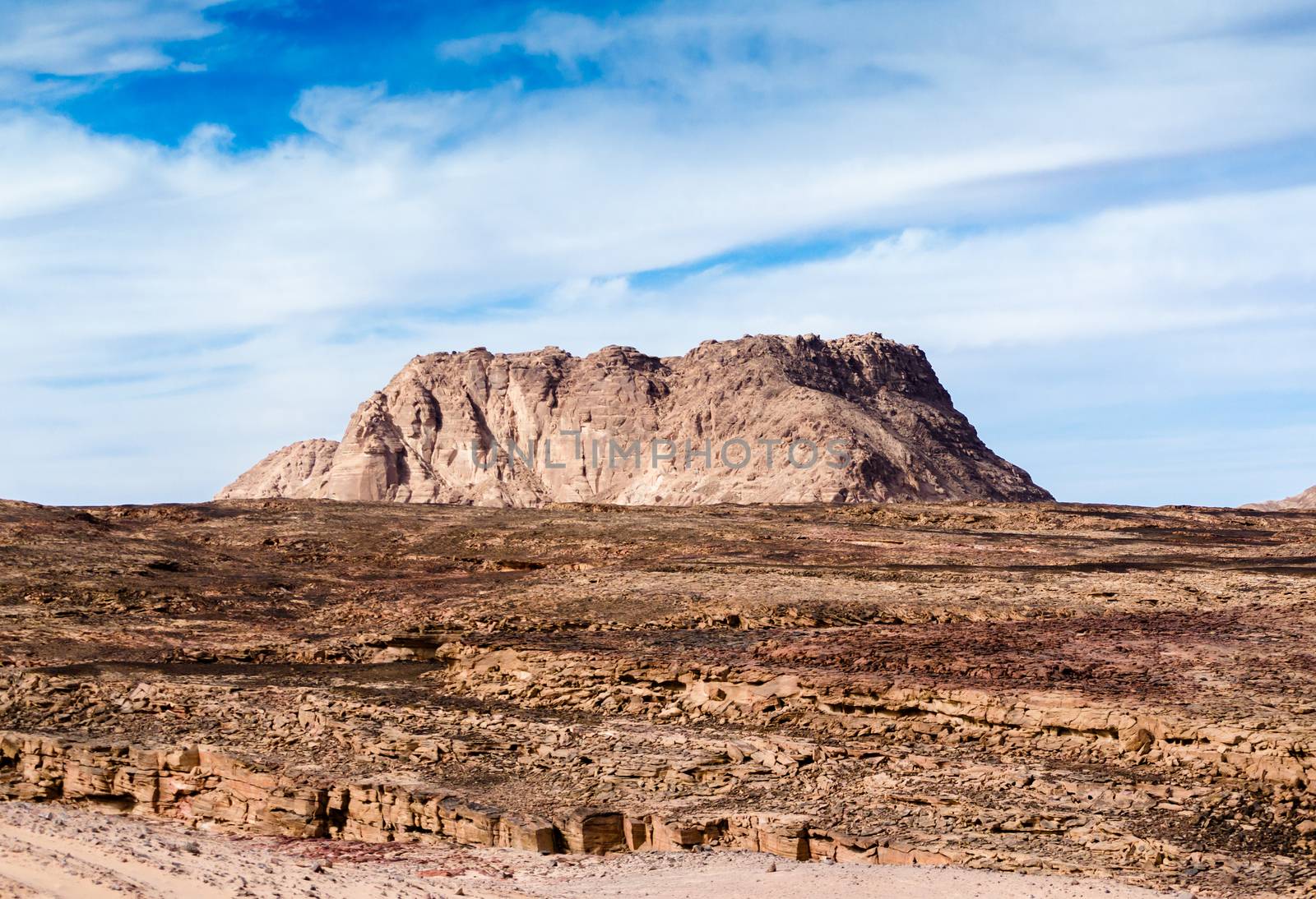 high mountain in the desert against the blue sky and white clouds