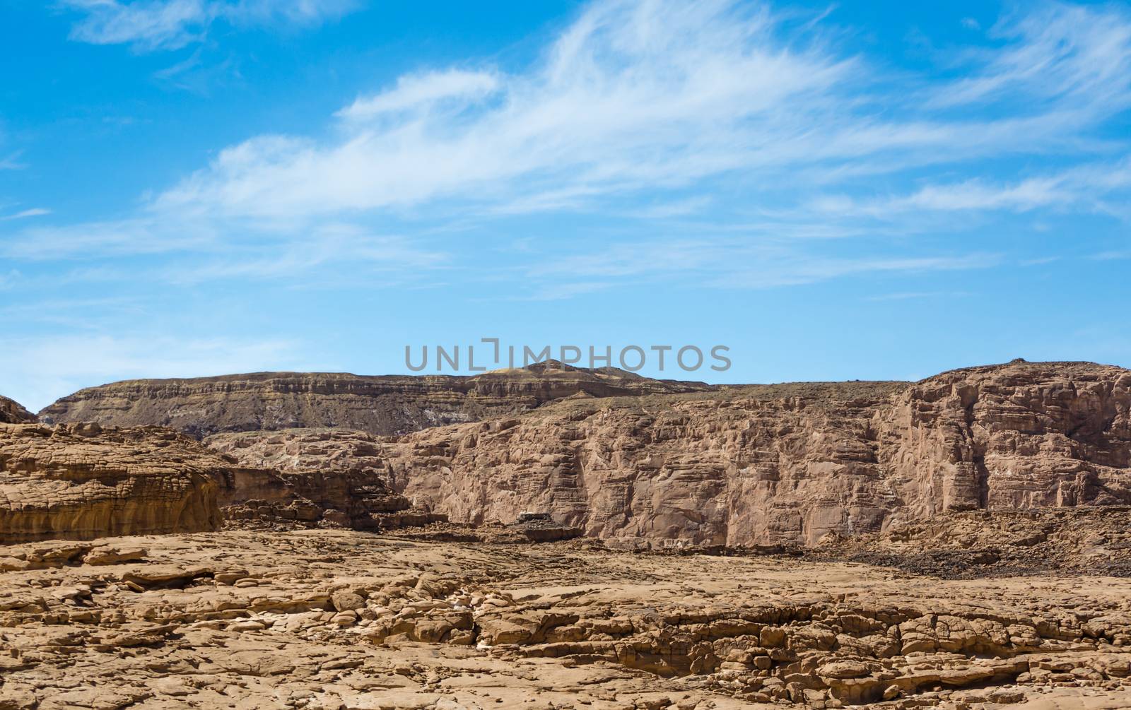 high rocky mountains in the desert against the blue sky and white clouds in Egypt Dahab