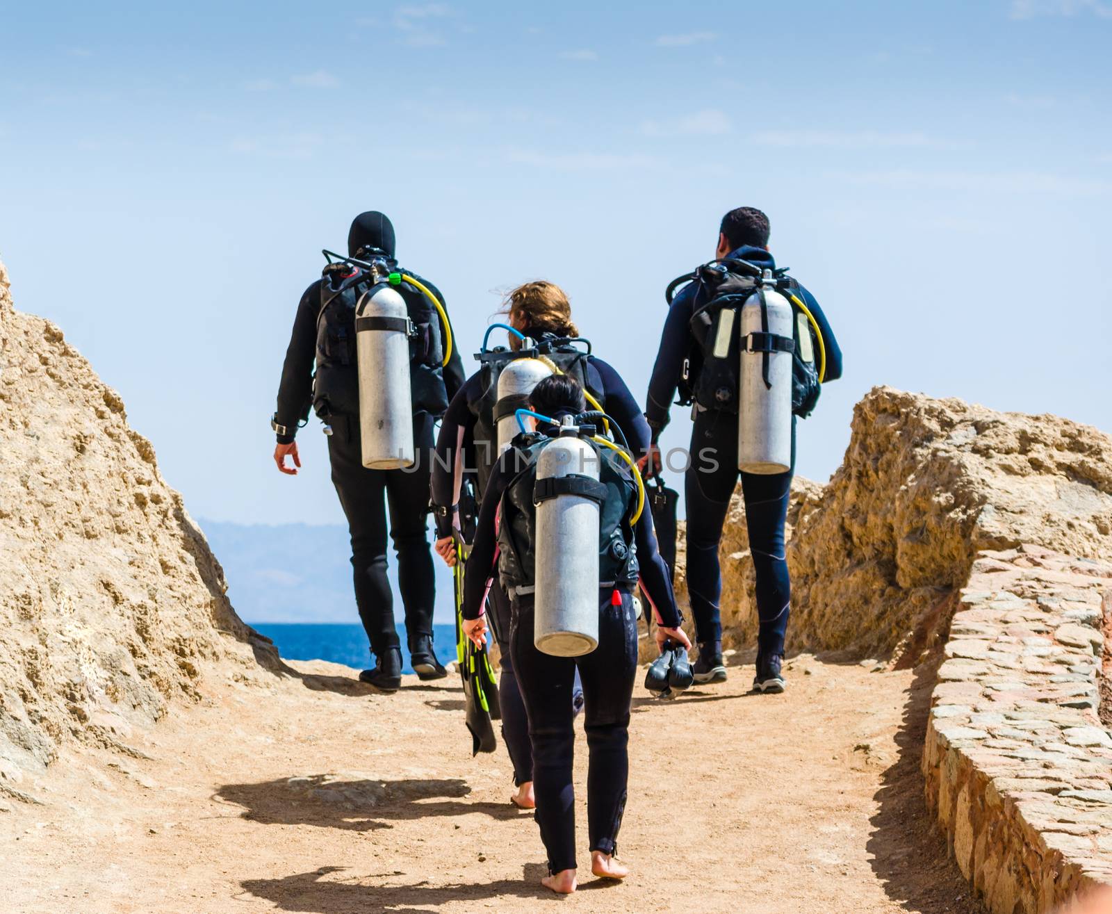 divers with equipment for diving under the water go to the sea on the sky with clouds in Egypt Dahab
