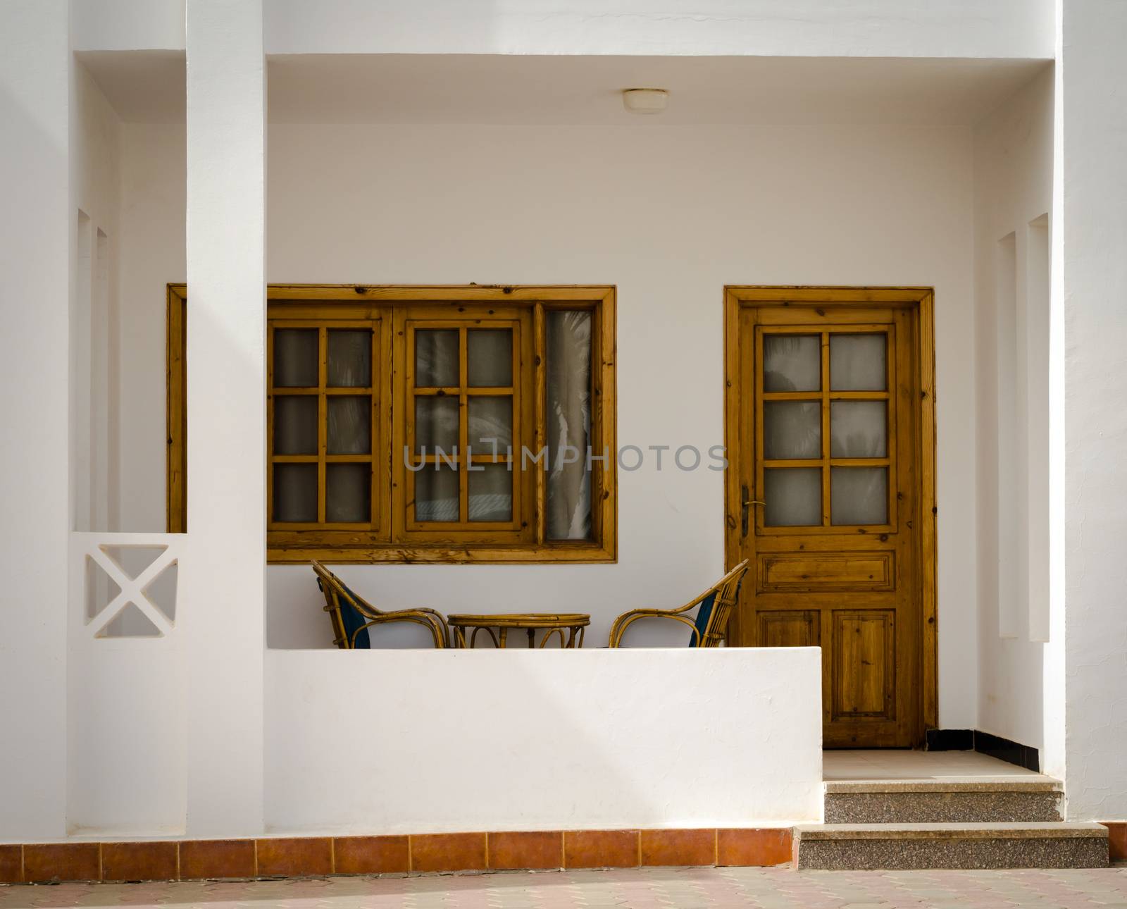 white holiday house with chairs and table
