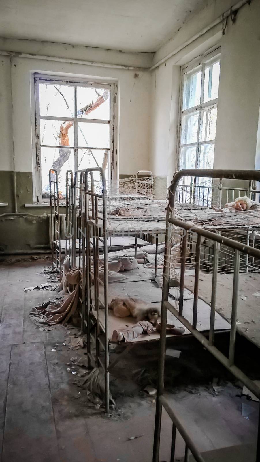 empty children's beds in an abandoned kindergarten house with peeling walls in Chernobyl