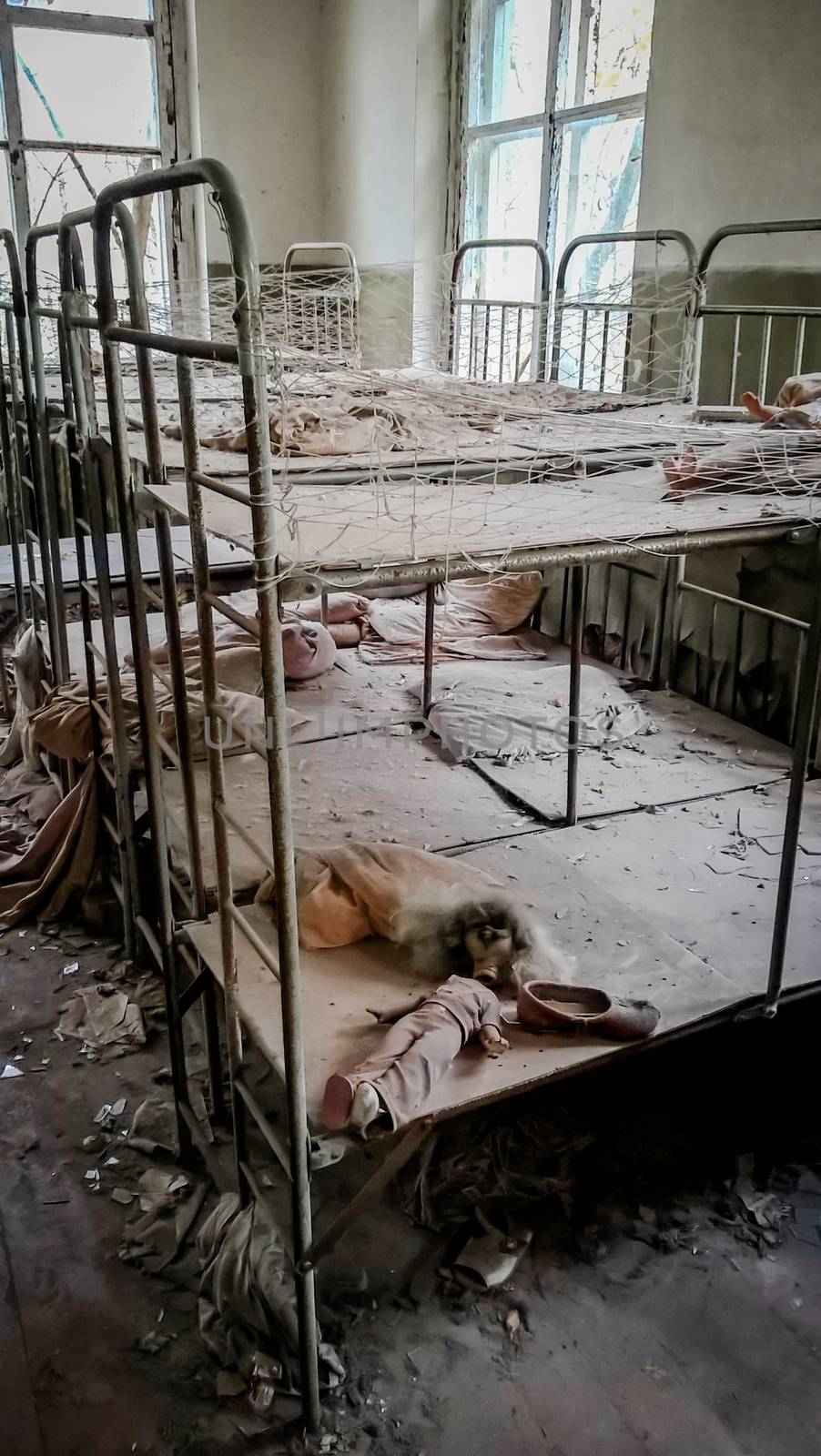 empty children's beds in an abandoned kindergarten house with peeling walls in Chernobyl