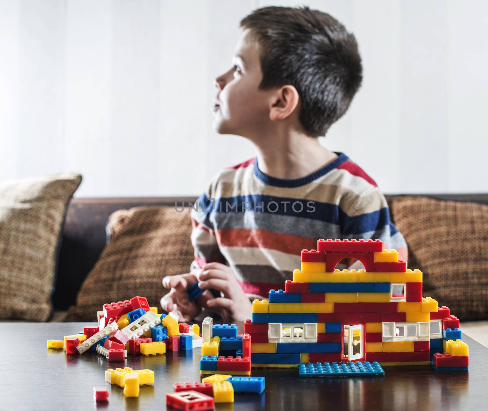 Child play with children's constructor toys. Multicolored cubes