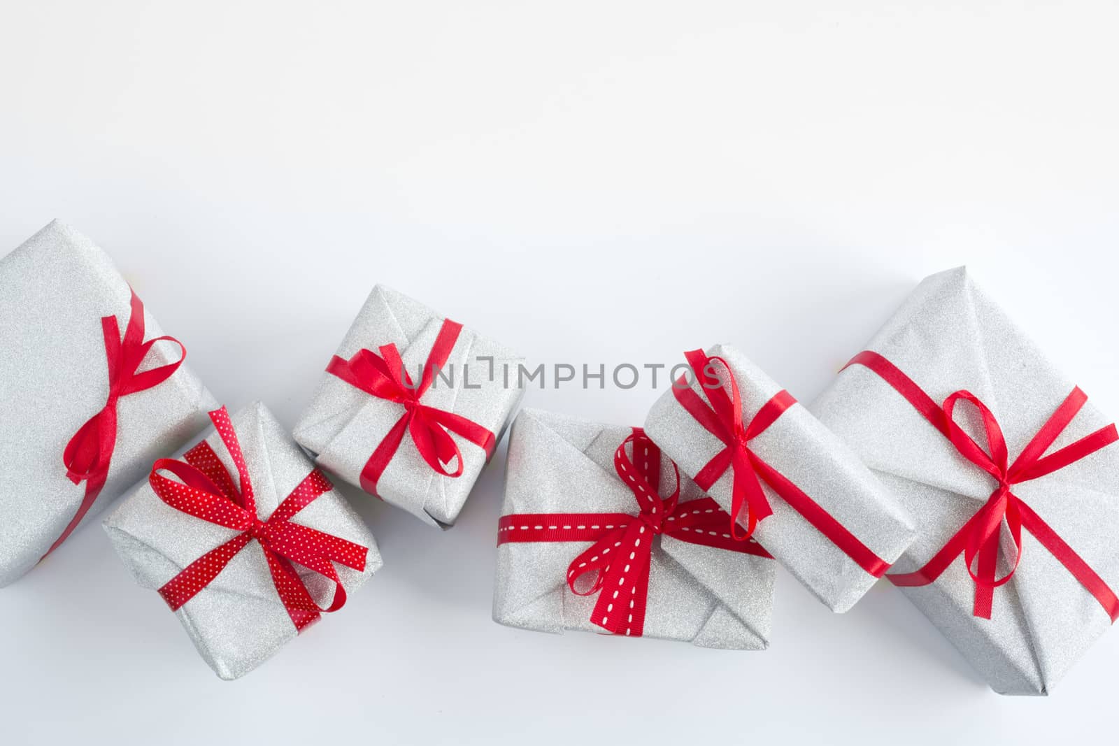 Border frame design element background of silver glitter gifts with red ribbon bow decoration isolated on white background top view flat lay composition with copy space for text