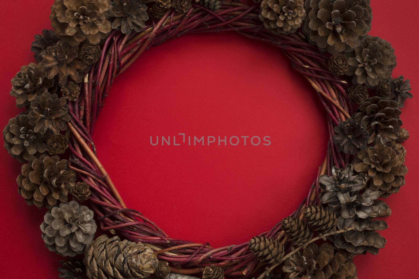 Christmas natural eco style spruce pine cone wreath over red background flat lay top view with copy space for text