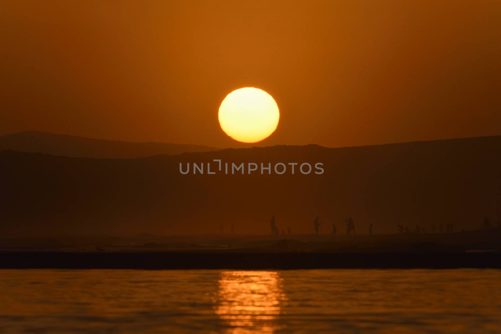 Last light on the African south coast as the sun sets behind a beach horizon, Mossel Bay, South Africa