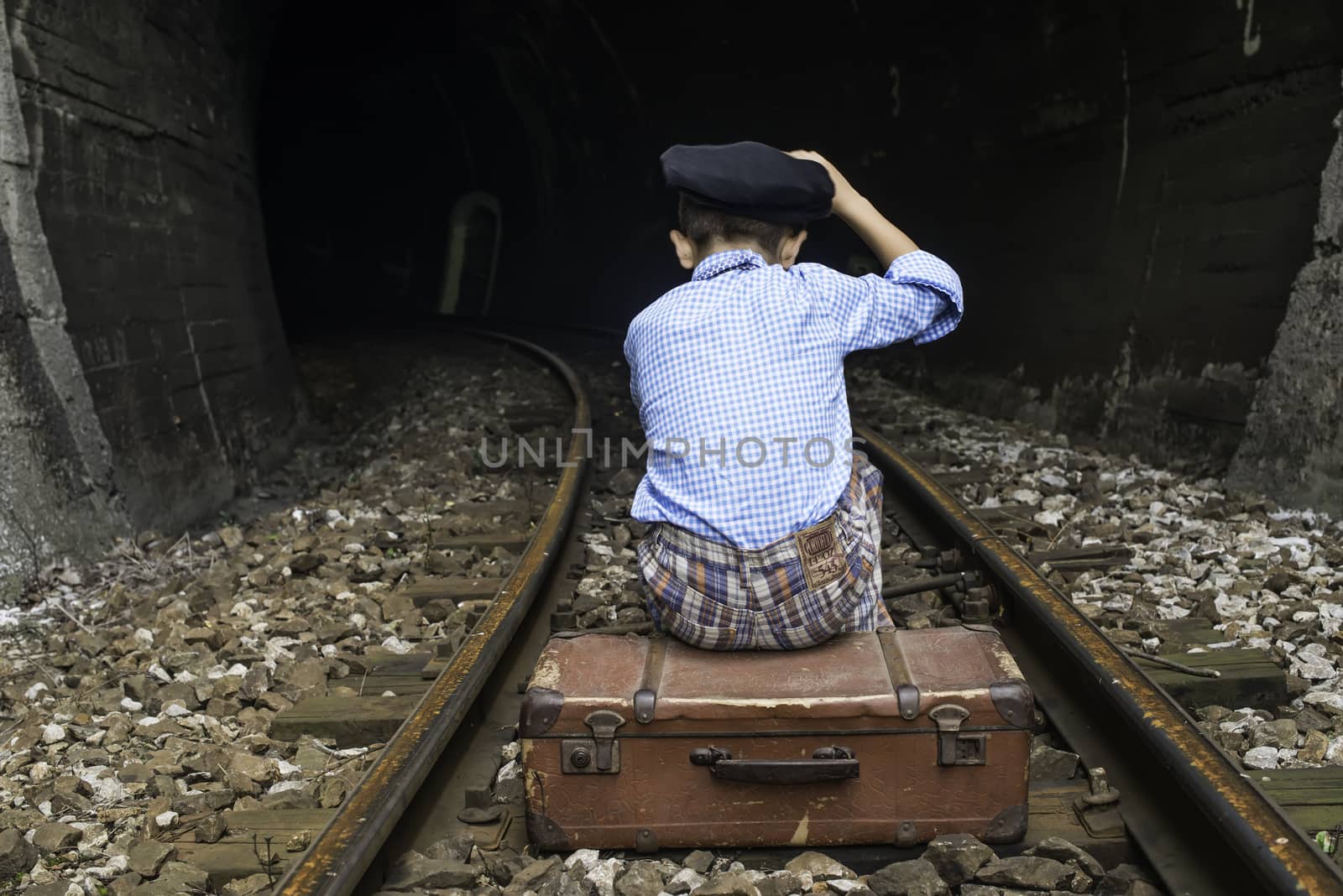 Child in vintage clothes sits on railway road by deyan_georgiev