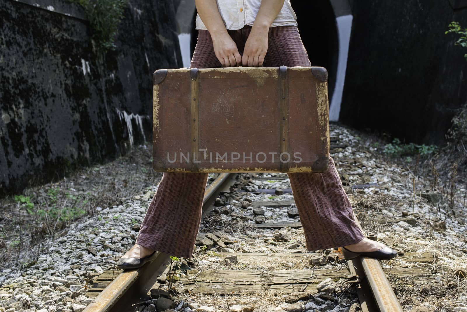 Woman and vintage suitcase on railway road by deyan_georgiev