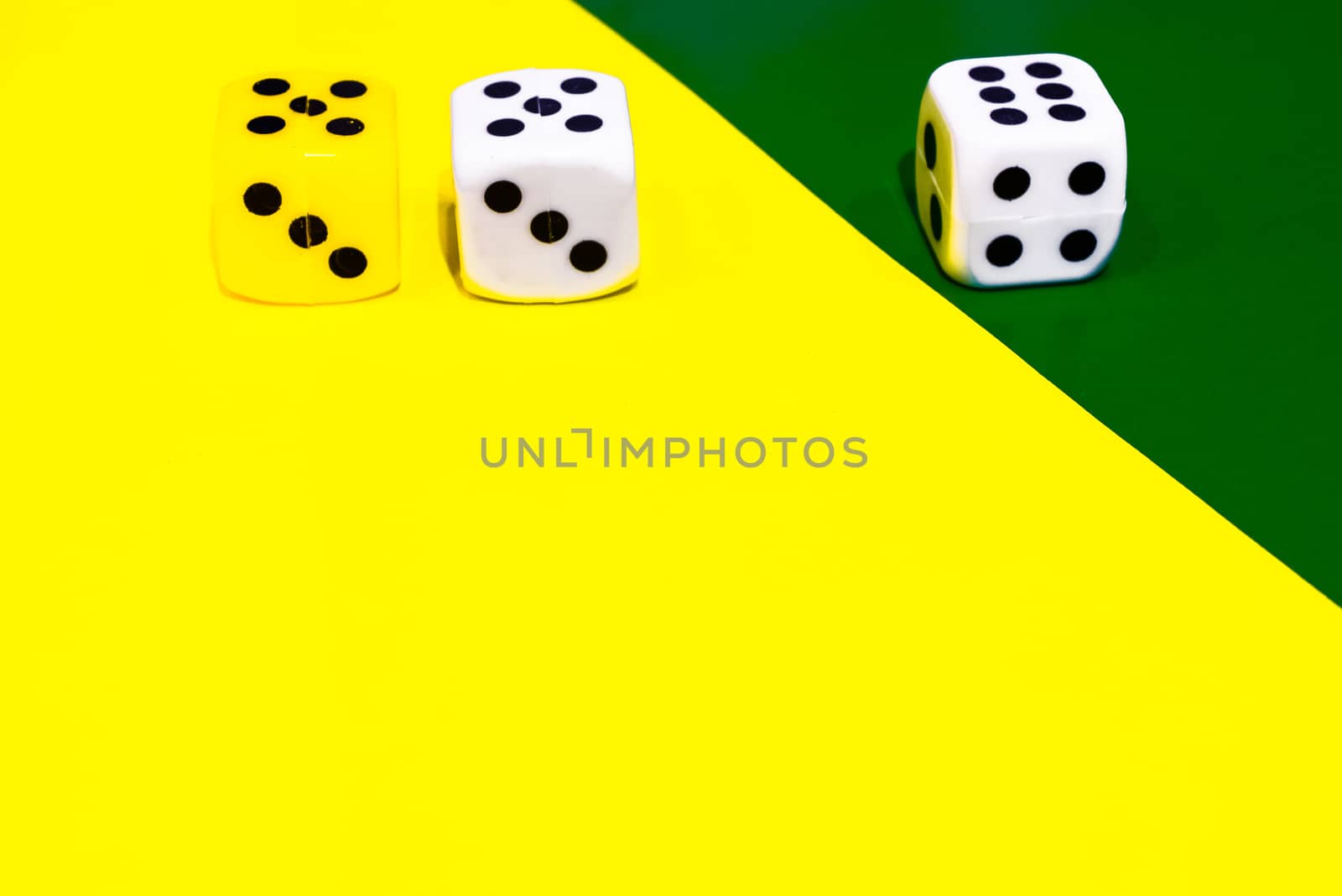 white and yellow dice on a combined green and yellow background