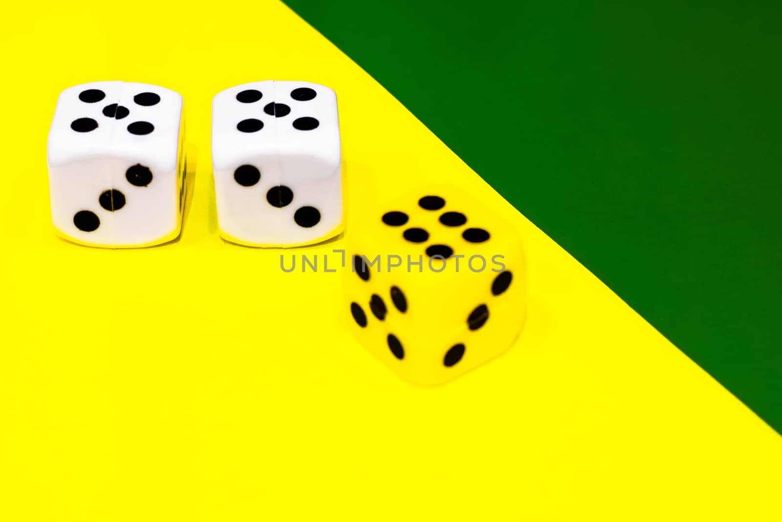 white and yellow dice on a combined green and yellow background