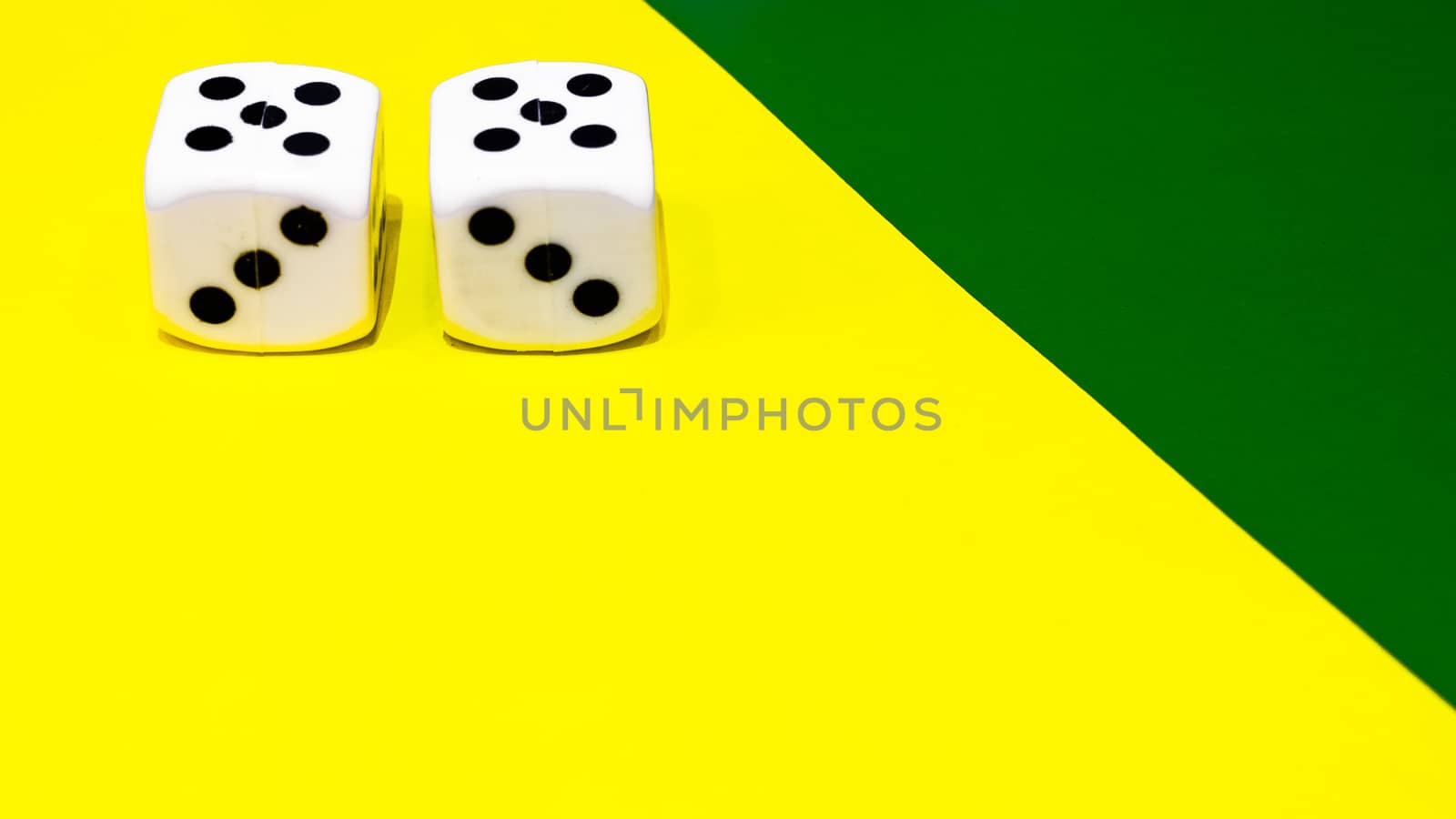 white and yellow dice on a combined green and yellow background