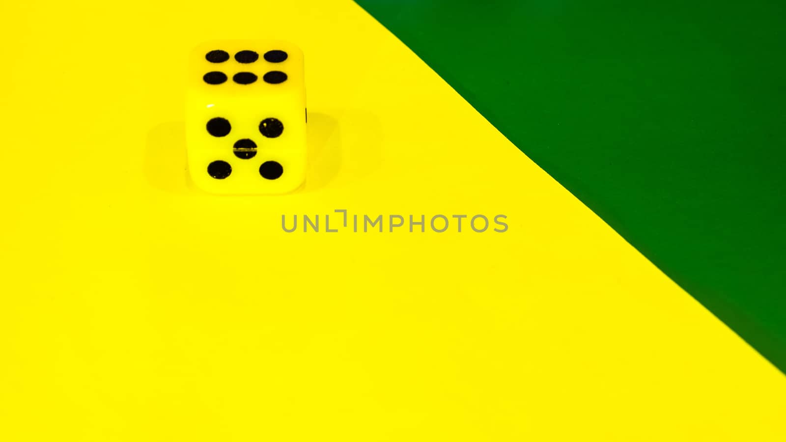 white and yellow dice on a combined green and yellow background