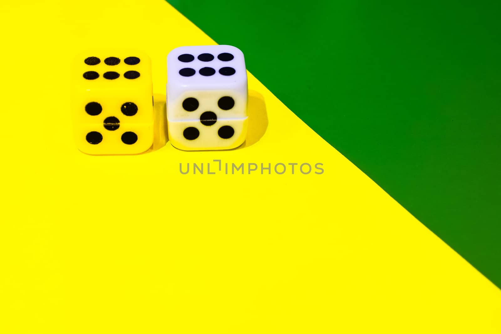 white and yellow dice on a combined green and yellow background