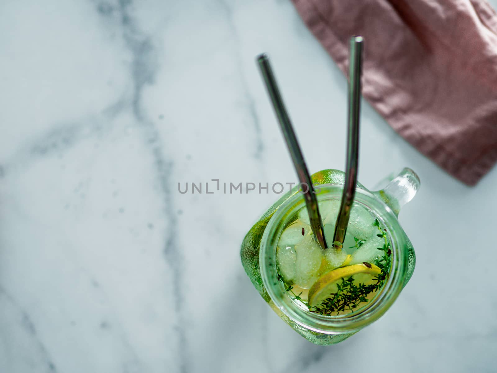 Metal drinking straws and cold drink in glass mason jar on white marble background. Top view or flat lay. Copy space for text or design. Recyclable straws, zero waste concept. Banner.