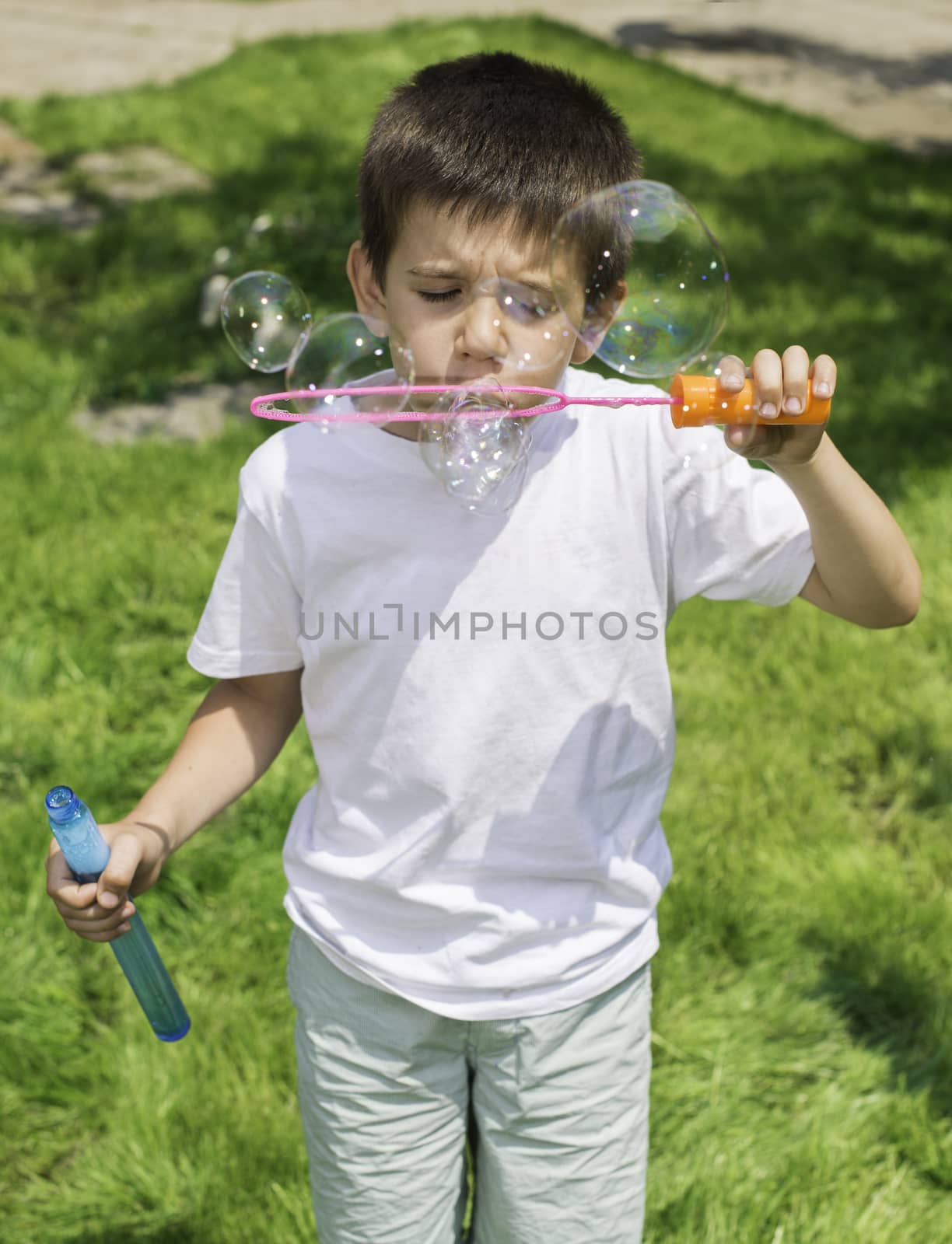 Child makes bubbles. Green park