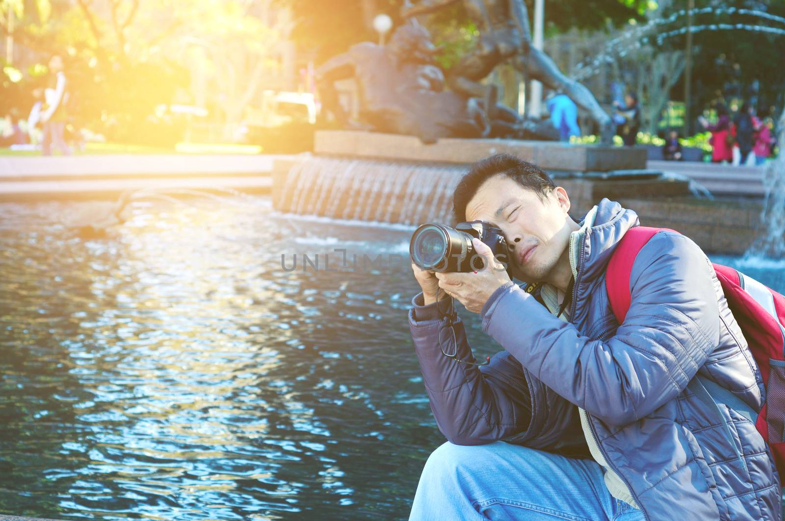 Asian Male tourist taking picture in the city of Sydney , Australia.