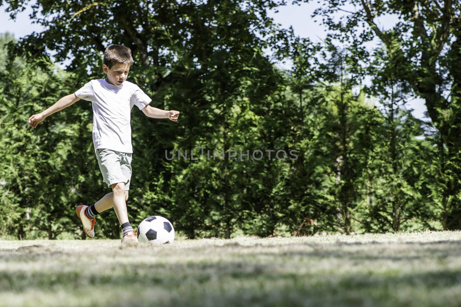 Child playing football in a stadium by deyan_georgiev