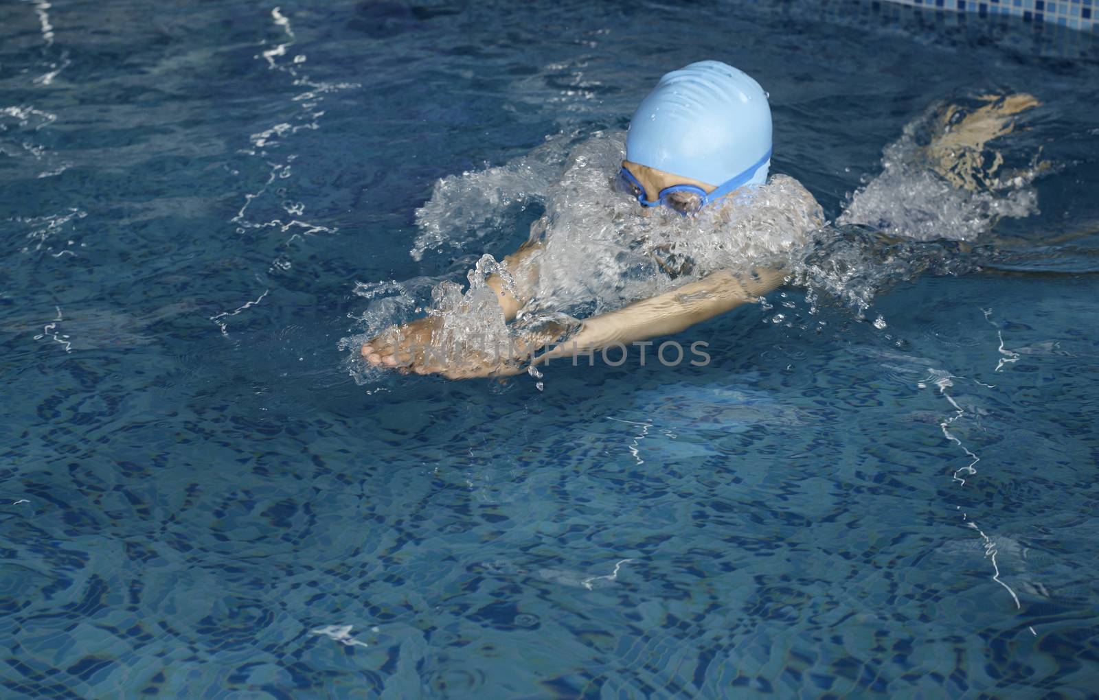 Child swimmer in swimming pool by deyan_georgiev