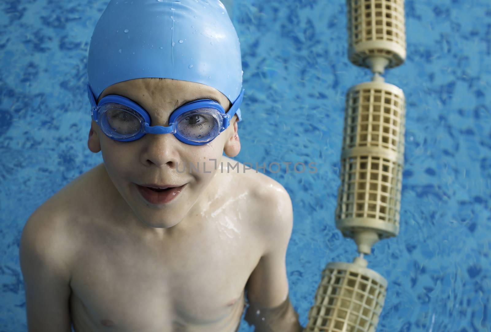 Little boy in swimming pool. Blue swimming pool.