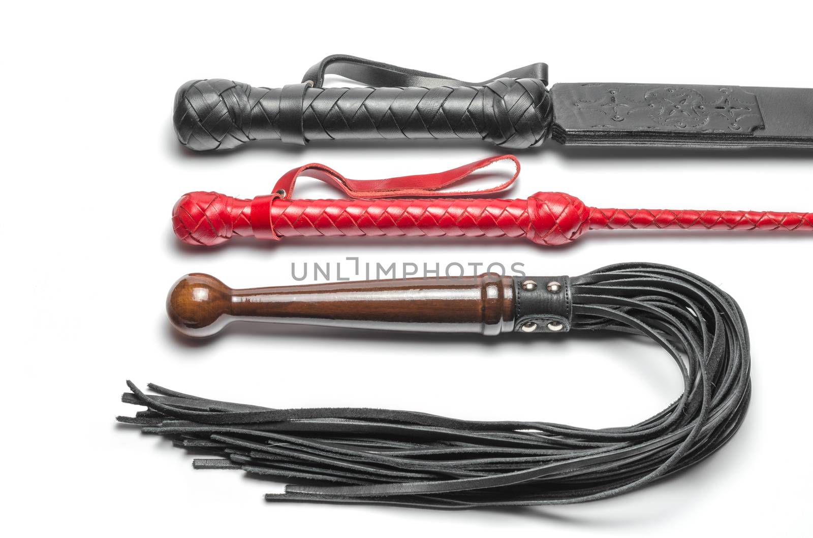 black and red three bdsm whips on a white background close up