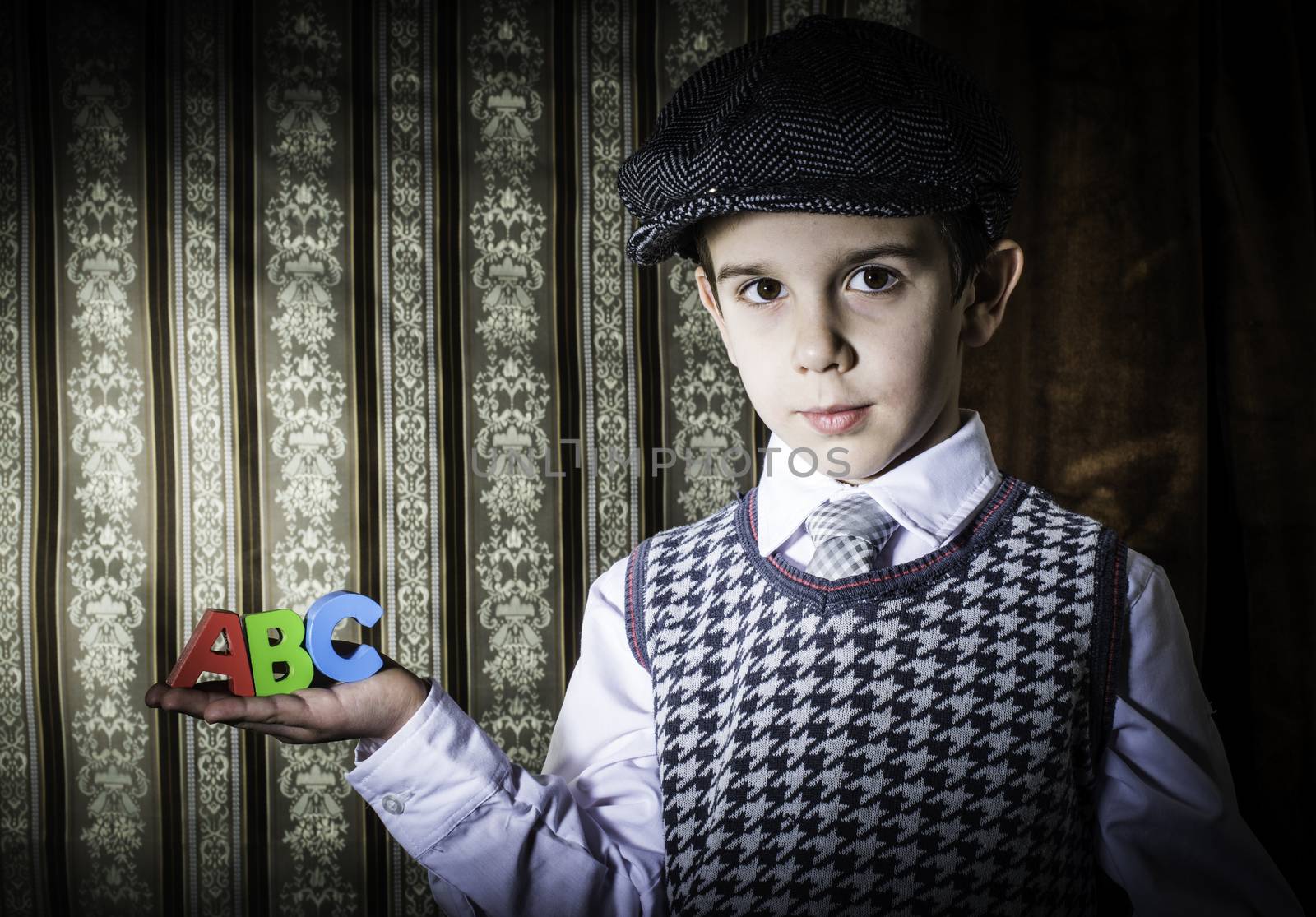 Child in vintage clothes hold letters a b c by deyan_georgiev