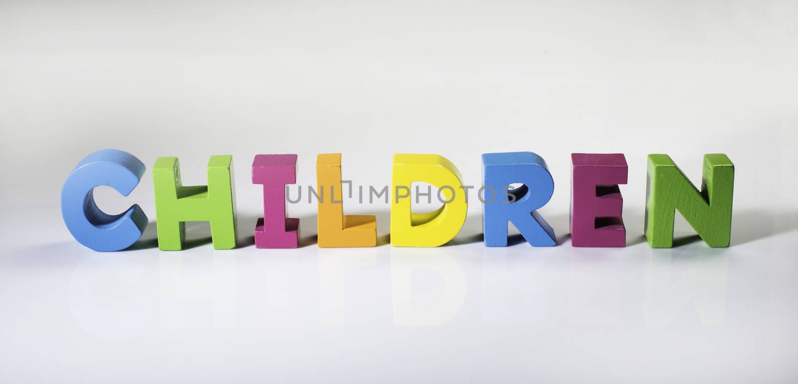 Multicolored text children made of wood. White background