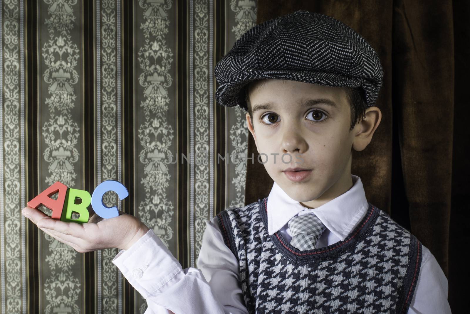 Child in vintage clothes hold letters a b c by deyan_georgiev