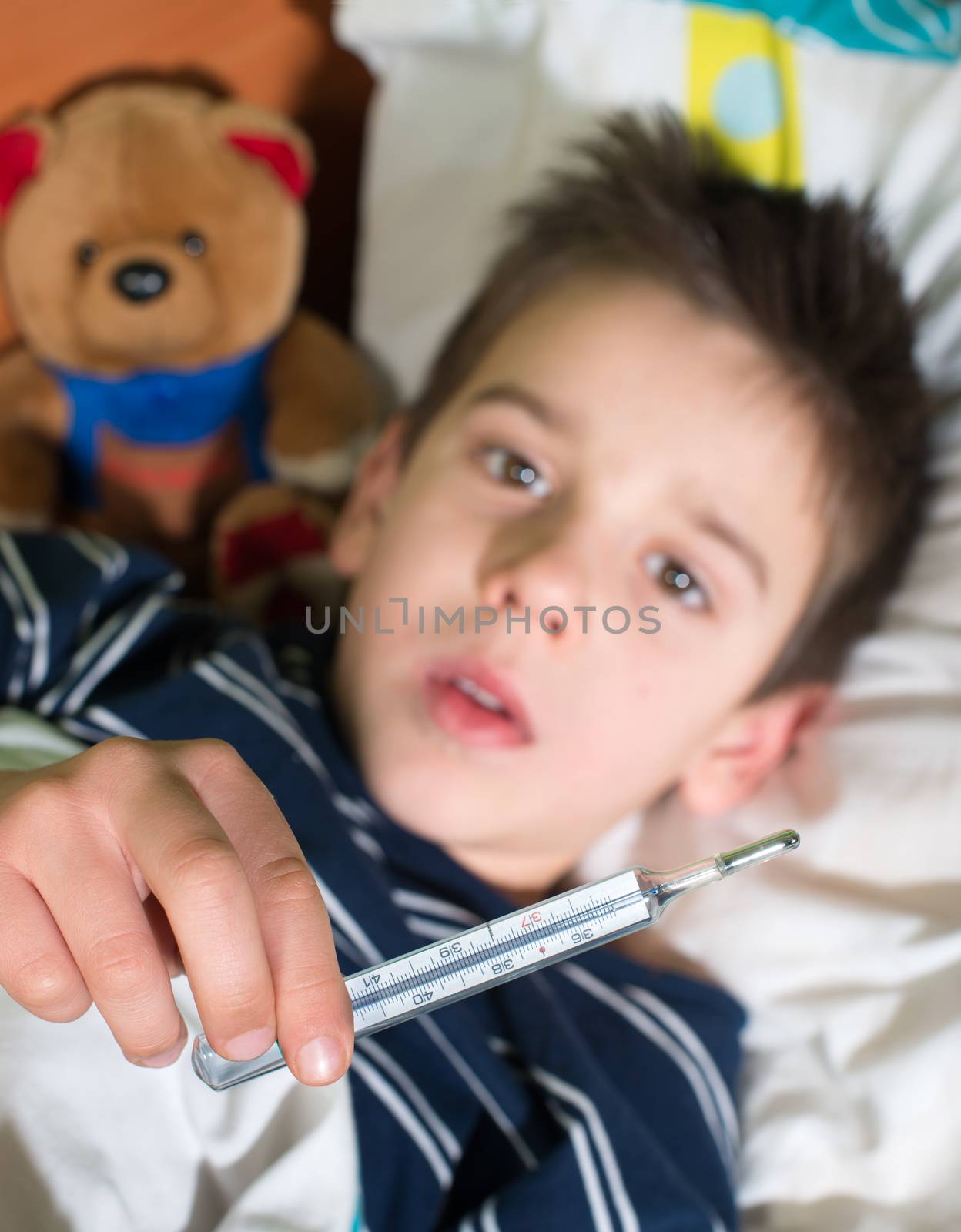 Sick child in bed with teddy bear by deyan_georgiev