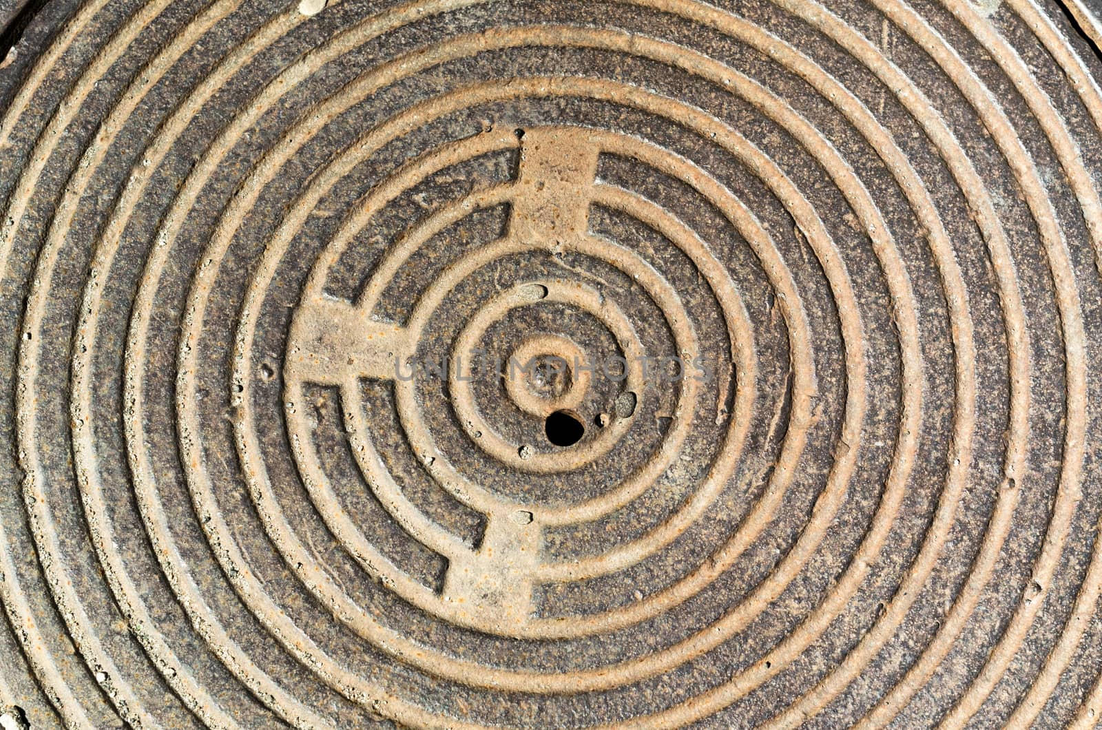 beige concentric round texture cast-iron hatch cover of brown rusty color