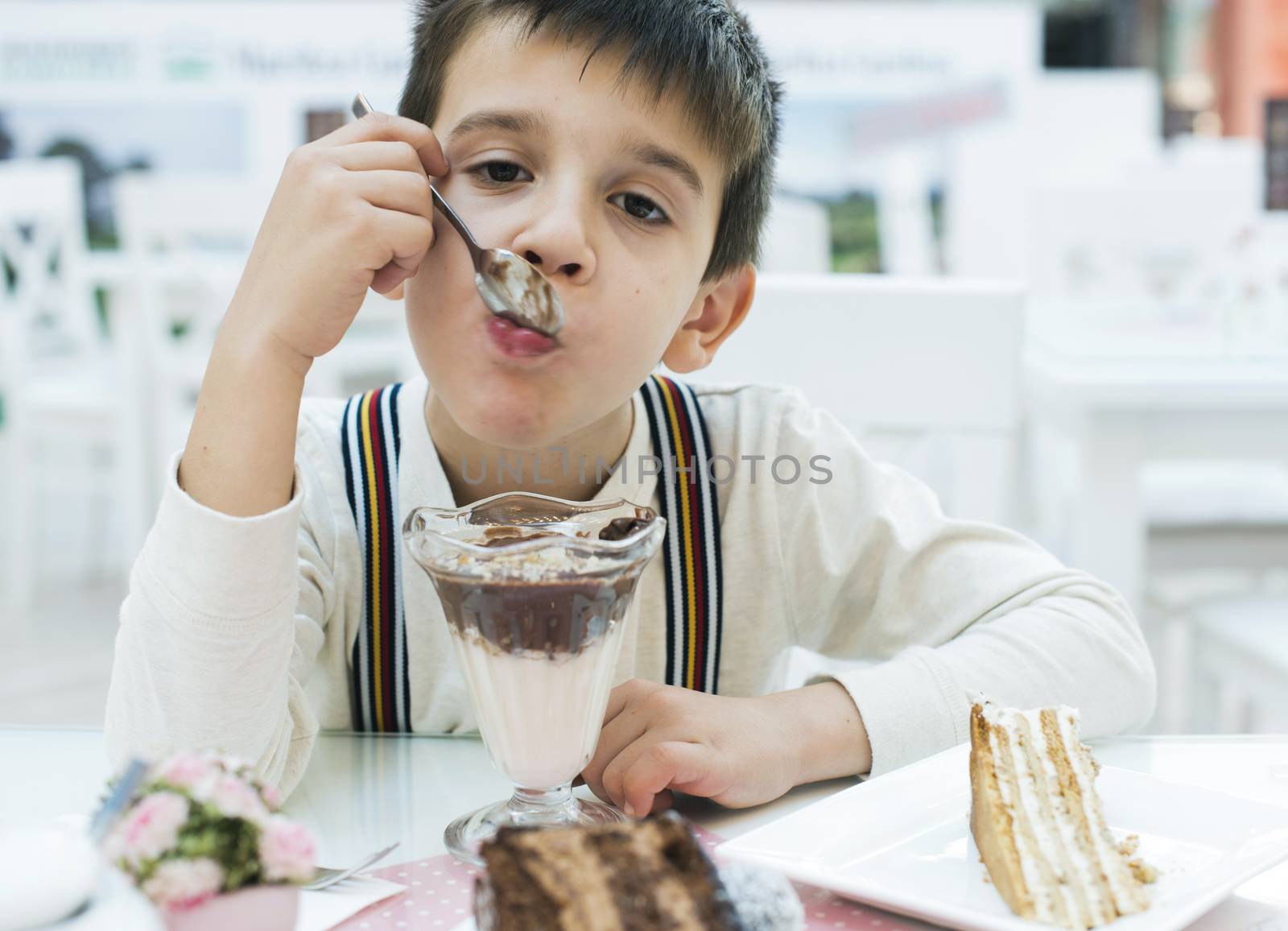 Child eat milk choco shake on a table
