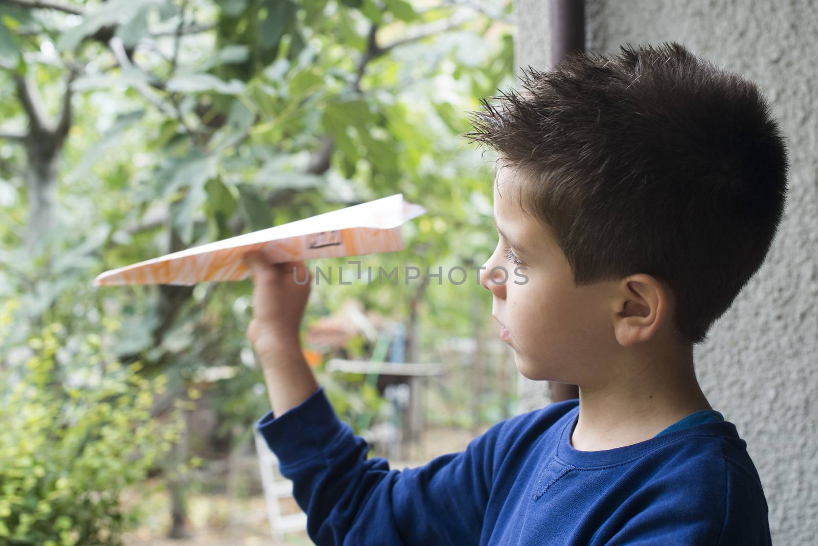 Kid throws paper plane. Authentic image