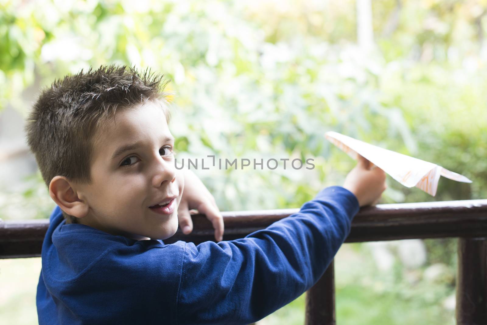 Kid throws paper plane. Authentic image
