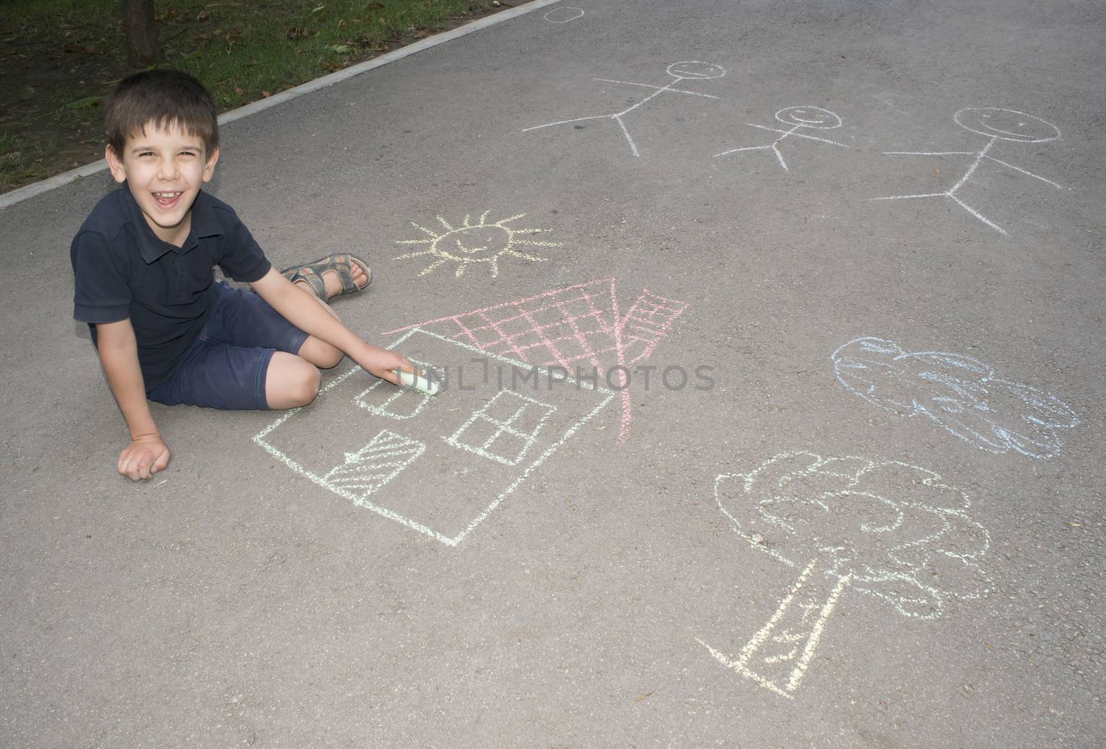 Child drawing sun and house on asphal by deyan_georgiev