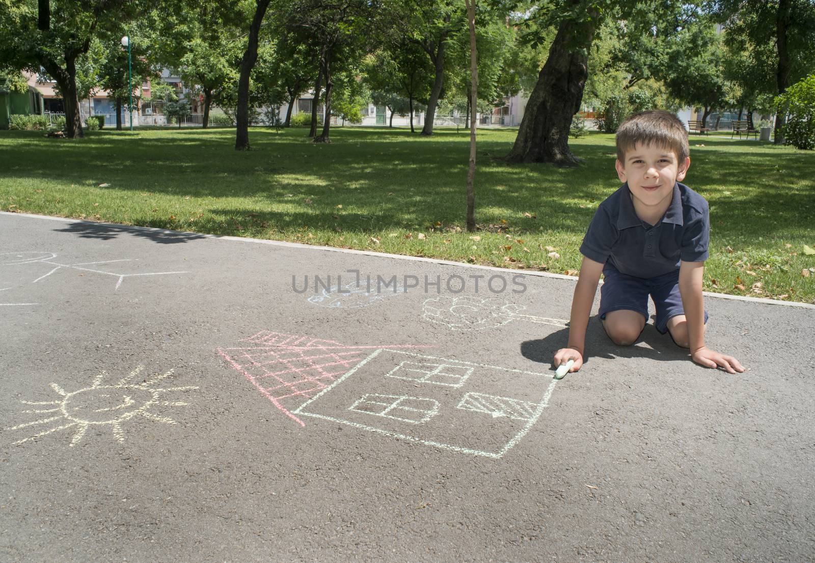Child drawing sun and house on asphalt by deyan_georgiev