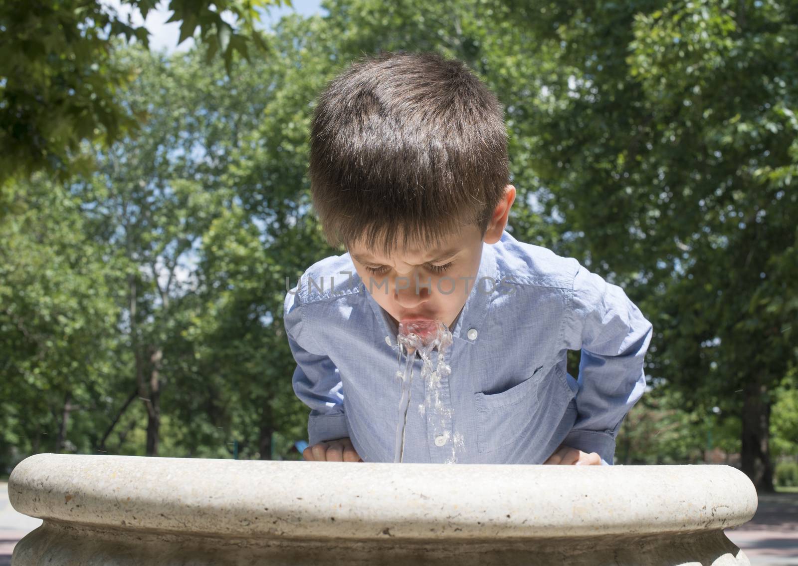 Child drinking water from a fountain by deyan_georgiev