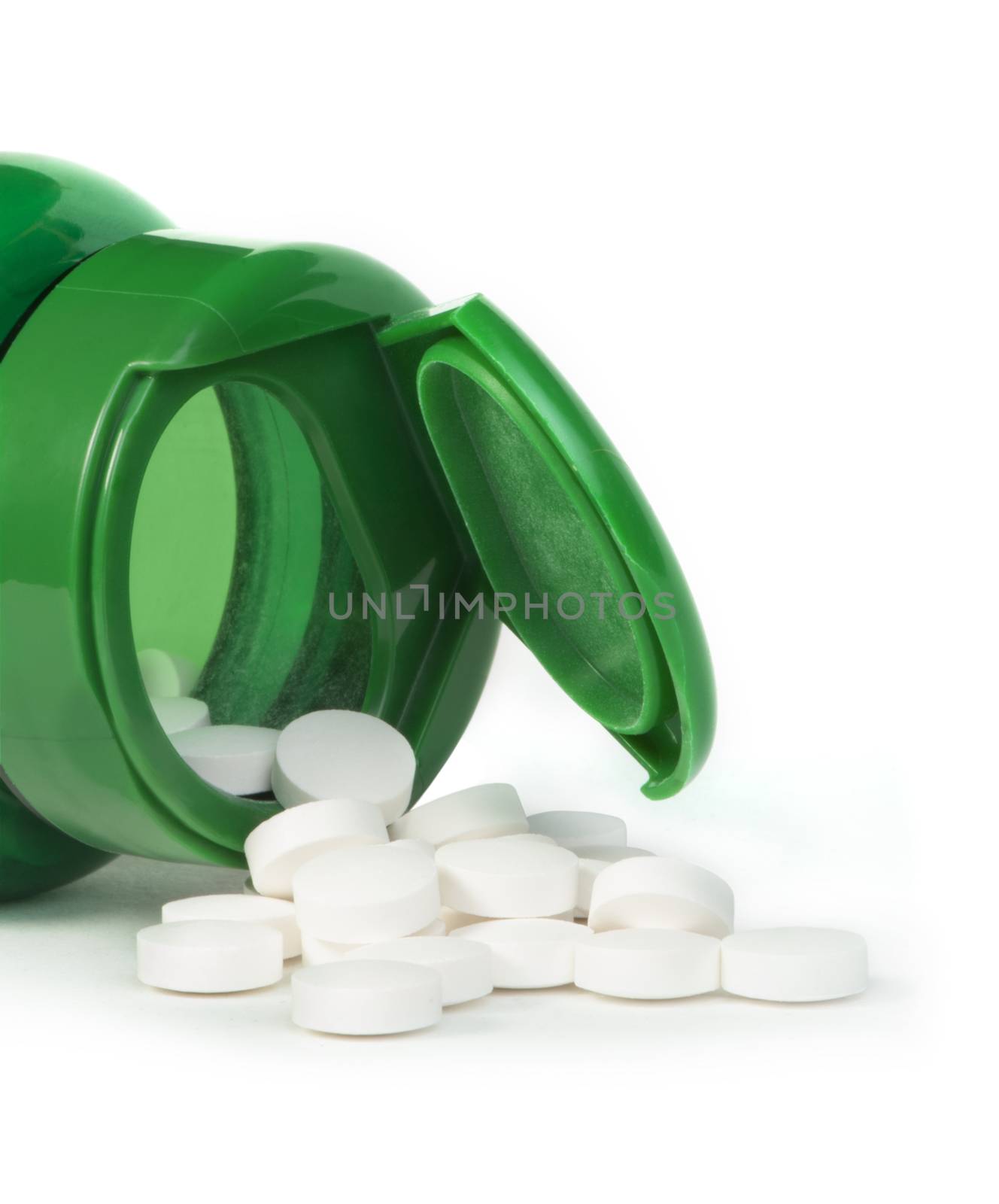 White pills and a container of pills. White siolated studio shot