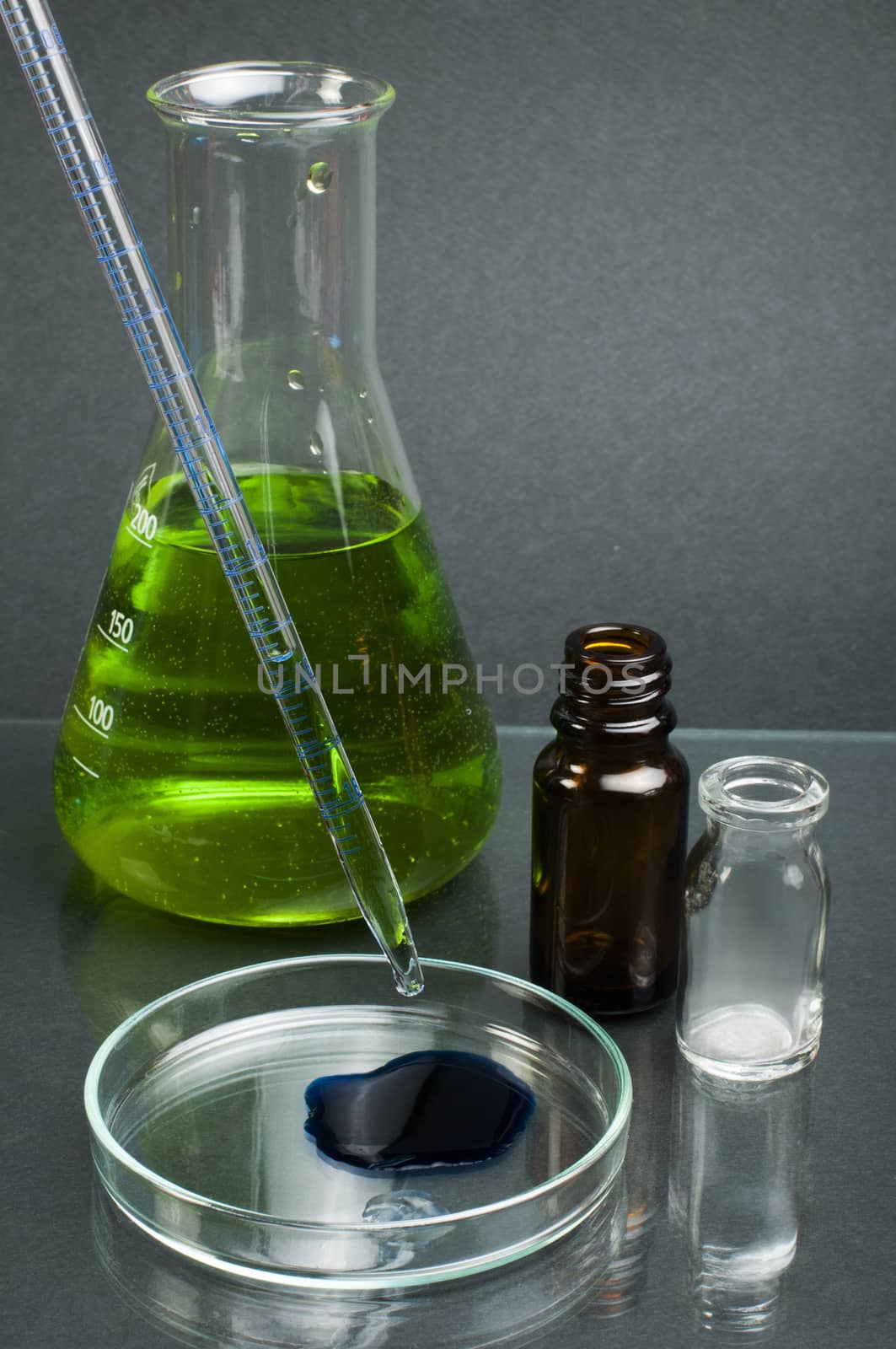 Laboratory beaker filled with green color liquid substances by deyan_georgiev