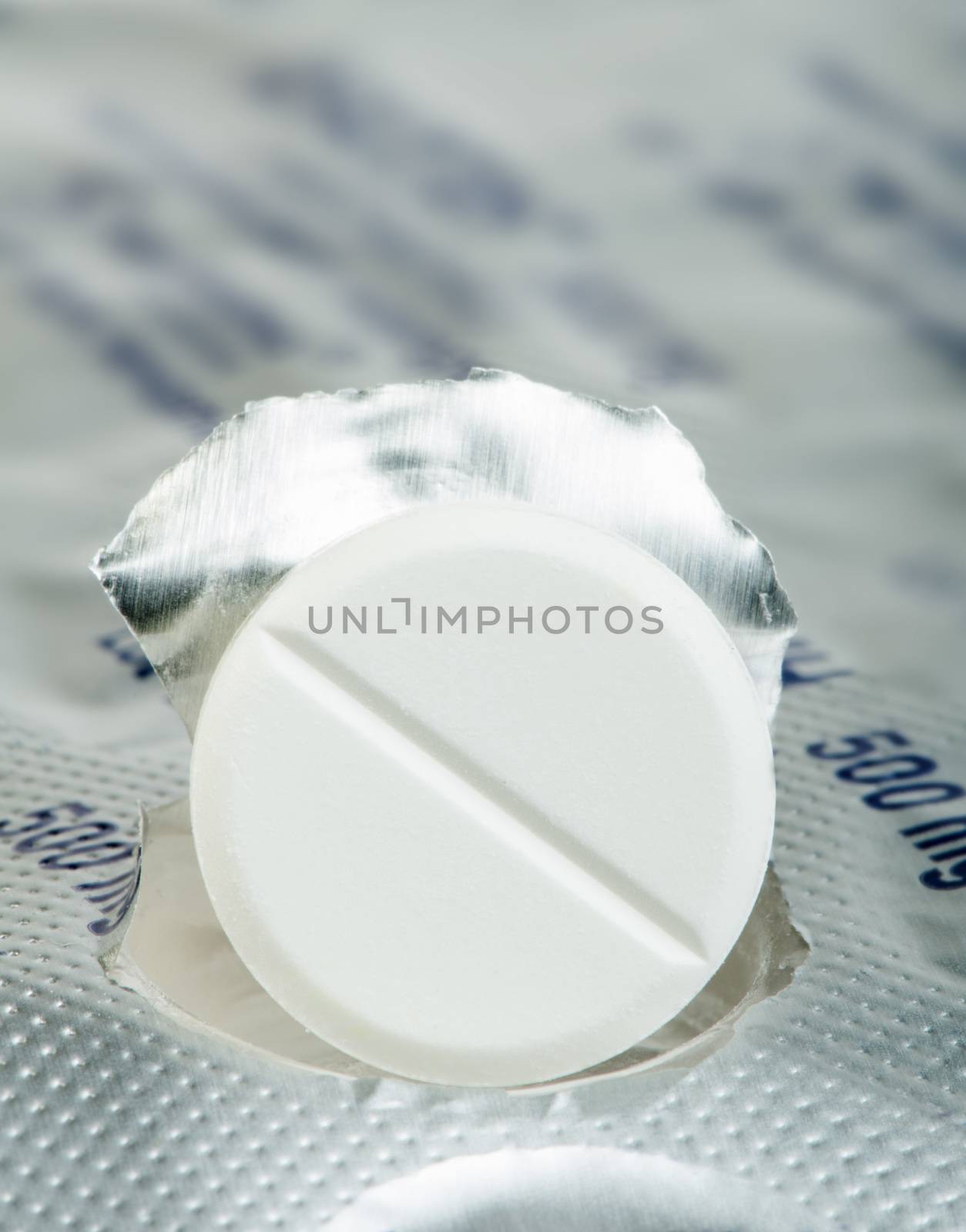 White pill in a pack very close up. Macro studio shot