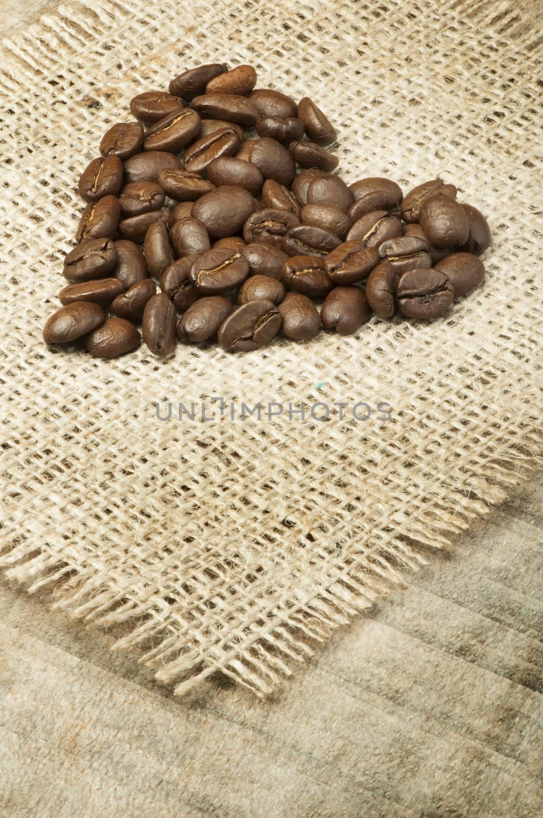Heart made ​​of coffee beans on burlap