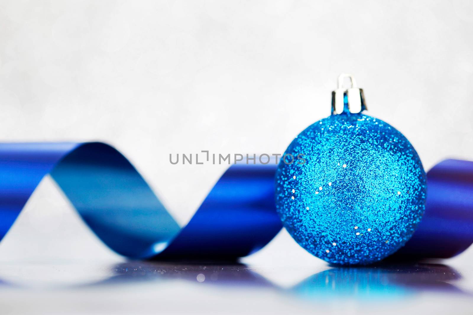 Beautiful Glitter christmas ball and ribbon close-up on shining background