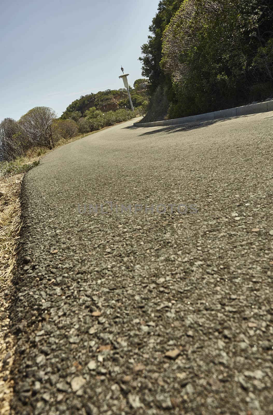 Detail of a small asphalt road flowing in the middle of Sardinia
