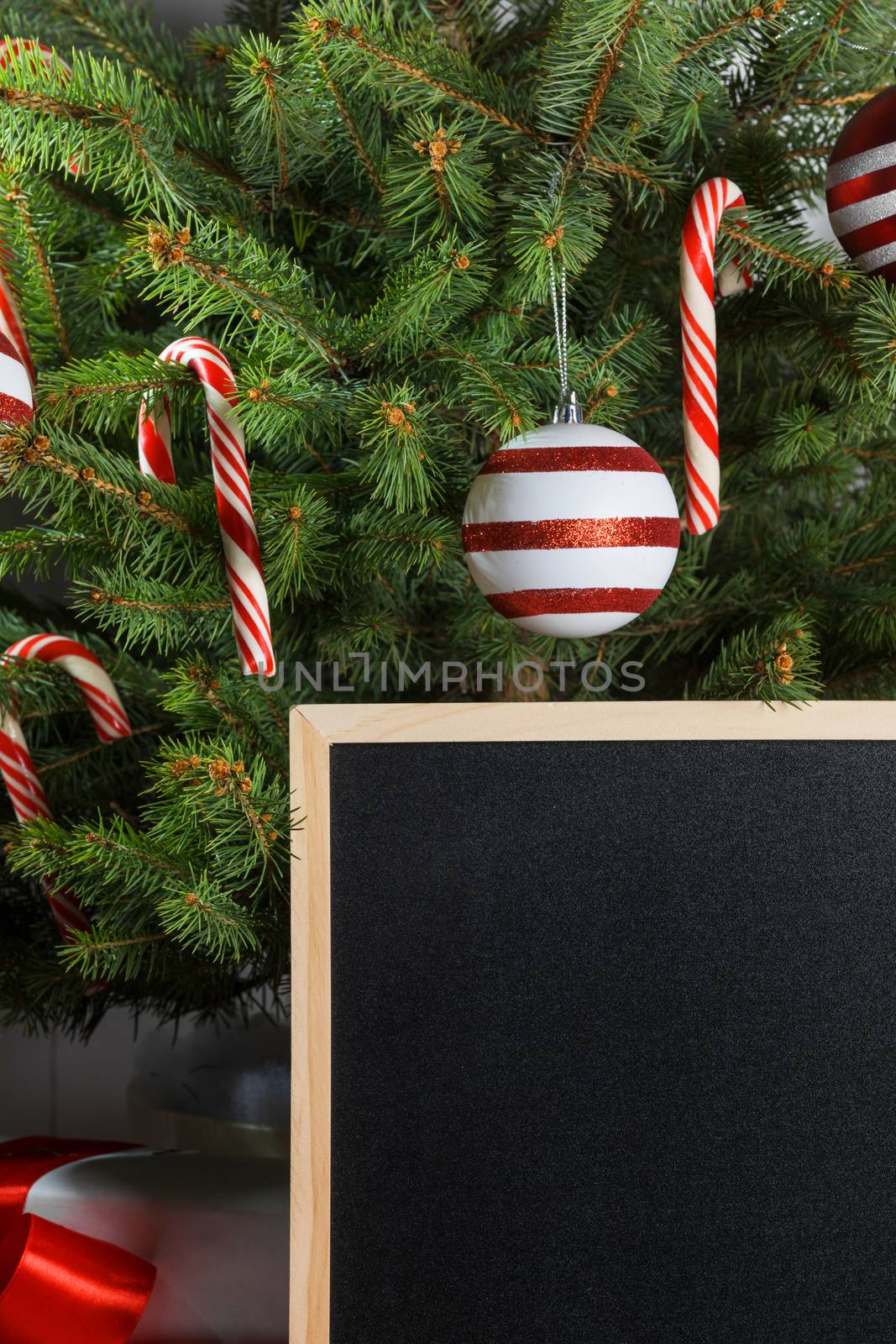 Rustic chalkboard and christmas tree decorated with candy canes and baubles