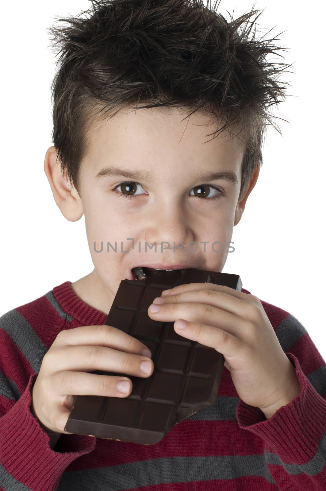 Smiling little boy eating chocolate. White isolated