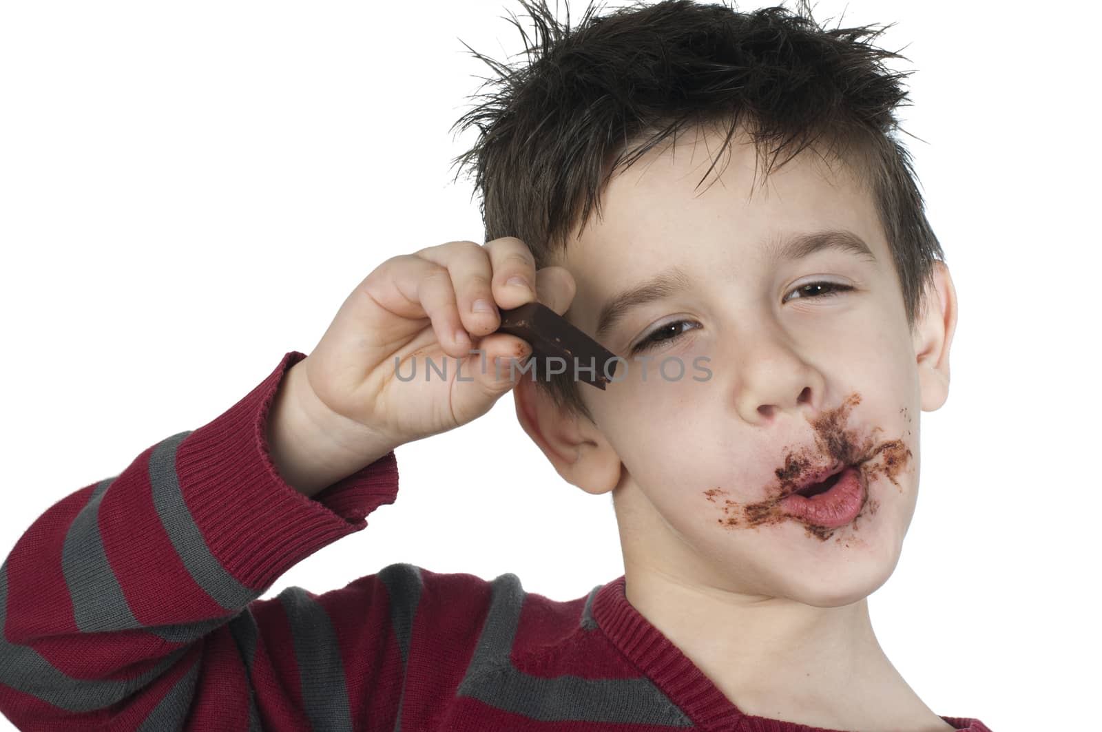 Smiling kid eating chocolate. Smeared stained with chocolate lips. White isolated