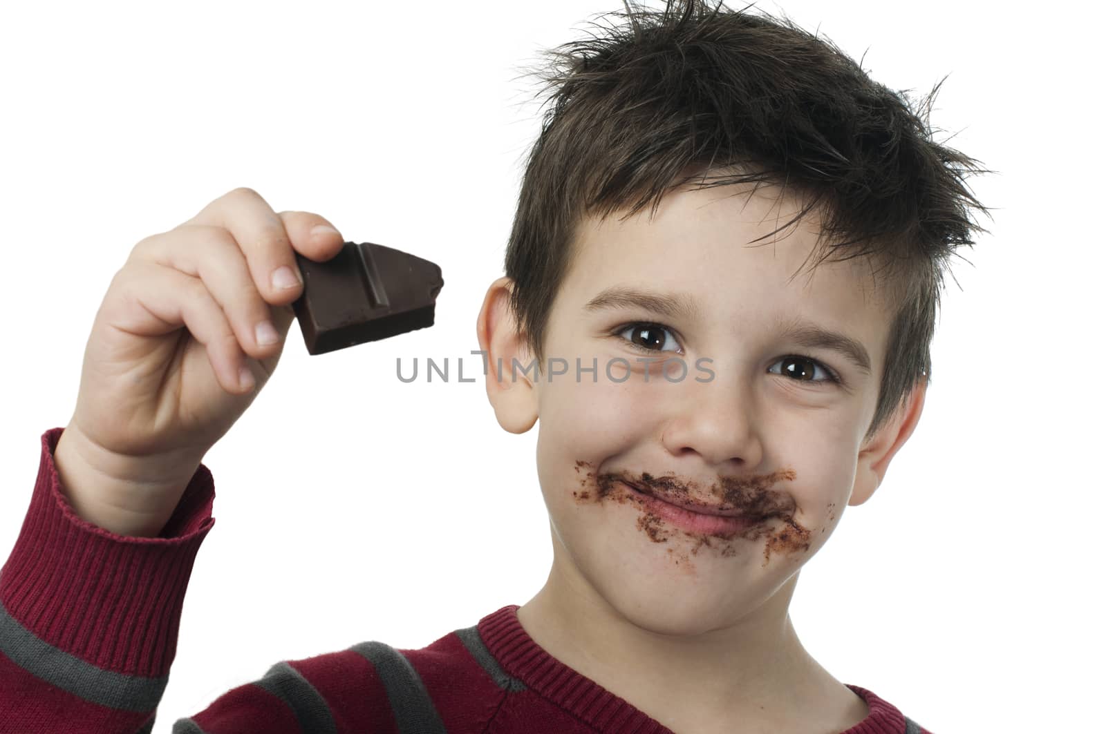 Smiling little boy eating chocolate by deyan_georgiev